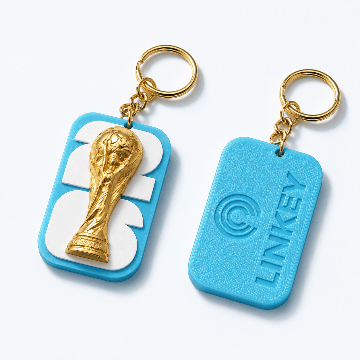 Llavero LiNKey: frente con trofeo del Mundial 2026 en relieve dorado y silicona celeste, atrás con el isologo LiNKey embossed